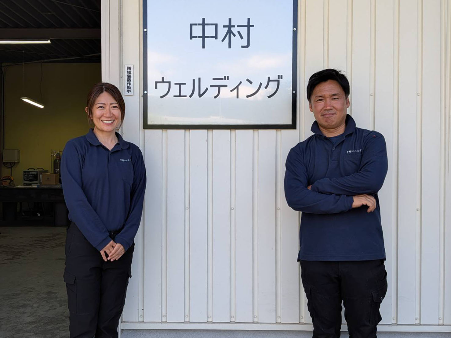 会社前で撮影したスタッフ写真